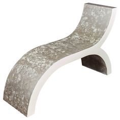 a white and grey curved bench sitting on top of a table