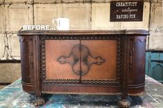 an old wooden cabinet with ornate carvings on the front and sides, sitting on top of a table