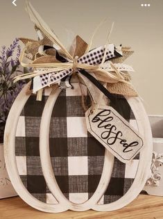 two white pumpkins with burlocks and ribbon tied around them on top of a table