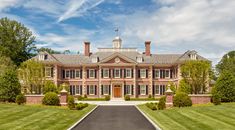 a large red brick house surrounded by lush green grass