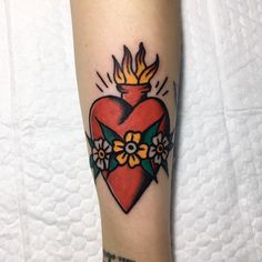 a tattoo on the leg of a woman with a heart and flowers