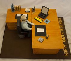 a cake shaped like a man sitting at a desk