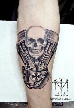 a man's leg with a skull and motorcycle engine tattoo on it