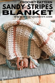 a crocheted blanket is laying on top of a wooden floor with the words sandy stripes blanket above it