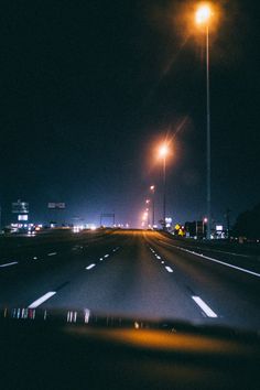 an empty highway at night with street lights