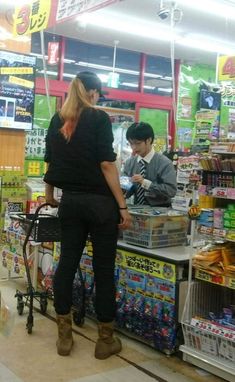 two people standing at the counter in a store