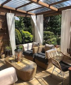 a covered patio with wicker furniture and curtains