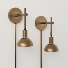 two brass colored wall lights with one light on each side and the other off to the side