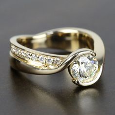 a close up of a ring with a diamond on it's center and two rows of diamonds in the middle