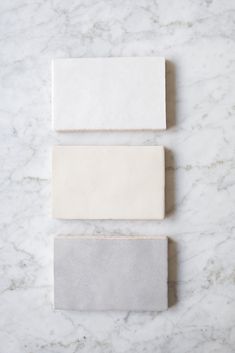 three white and gray tiles on a marble surface