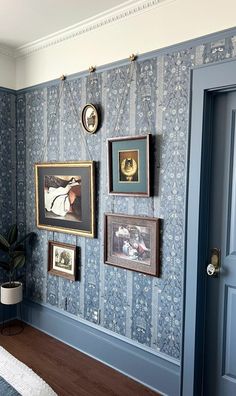 a bedroom with blue walls and pictures on the wall