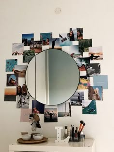 a mirror is hanging on the wall above a dresser with various photos and brushes in it