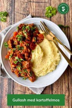 a white plate topped with mashed potatoes covered in meat and garnished with parsley