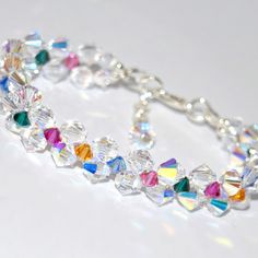 a close up of a bracelet on a white surface with lots of crystals in it