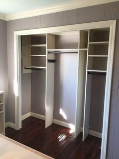 an empty bedroom with white closets and wood floors