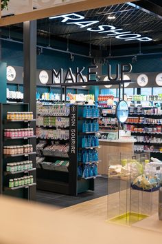 the inside of a store with various items on display and in front of it is a sign that says make up