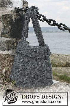 a handbag is hanging from a chain by the water's edge with an ad for drops design on it