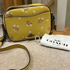 New Authentic Coach Floral Bow Camera Bag. Flax Yellow With Small Flowers And Bows In Pink Glitter. Black Hardware Adds A Nice Contrast. Adjustable Crossbody Mixed Chain Strap Is Removable. Front And Back Exterior Pockets. Slide In And Zipper Interior Pockets. Ring Zipper Pull With Fringe Accent. 8 Across X 6 High X 3 Deep. Dust Bag Included. Thanks For Shopping With Me. Coach Floral, Brown Leather Crossbody Bag, Coach Crossbody Purse, Vintage Gloves, Hippie Bags, City Bag, Coach Crossbody Bag, Slide In, Small Purse