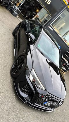 a black sports car parked in front of a building