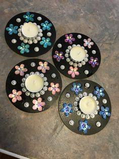 three black plates with flowers and candles on them sitting on a counter top next to each other