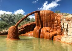 an orange rock formation in the water