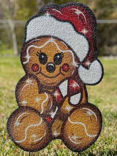 a teddy bear with a santa hat on it's head sitting in the grass