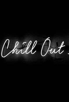 a black and white photo of a neon sign with the words chill out on it