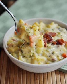 a white bowl filled with macaroni and cheese on top of a wooden table