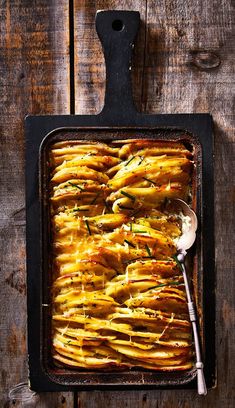 baked potatoes in a baking dish with a spoon on the side, ready to be eaten