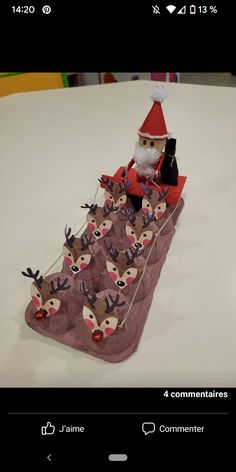 a santa clause sitting on top of a pile of reindeer