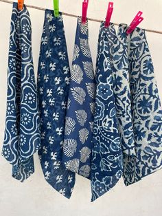 four blue and white cloths hanging on a clothes line