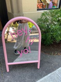 there is a pink sign that says keep calm and love on the sidewalk in front of a building