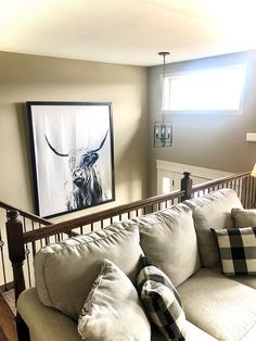 a living room filled with furniture and a painting on the wall above it's head