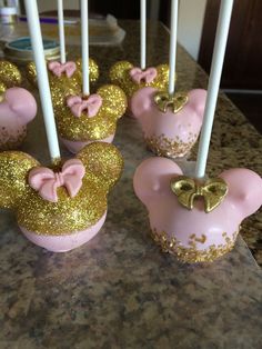 pink and gold mickey mouse cake pops with bows on them are ready to be eaten