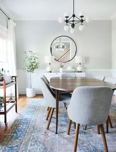 a dining room table and chairs with a rug on the floor in front of it