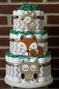 a three tiered diaper cake with woodland animals on it