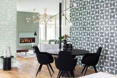 a dining room table with black chairs and a fireplace in the backround behind it