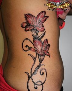 a woman's stomach with a flower tattoo on it