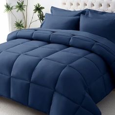 a bed with blue comforters and pillows on it