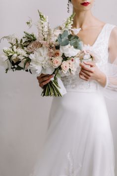 a woman holding a bouquet of flowers in her hands