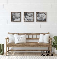 a wooden bench sitting in front of two pictures on the wall next to a potted plant