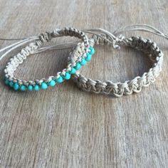 two bracelets with turquoise beads are sitting on a table