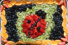 a square shaped fruit platter filled with kiwis, oranges, and strawberries