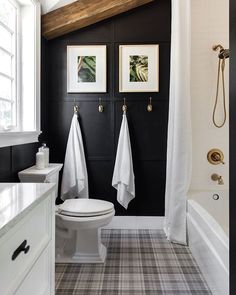 a white toilet sitting next to a bath tub in a bathroom under a wooden ceiling