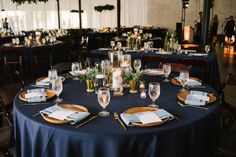 the table is set with place settings for dinner and wine glasses, napkins, and candles