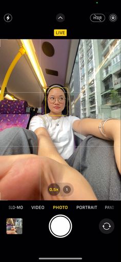 a person taking a selfie with their cell phone in front of them and the other hand on her leg