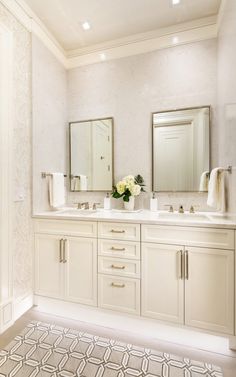 a white bathroom with two sinks and mirrors