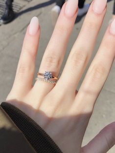 a woman's hand with a ring on it and a diamond in the middle