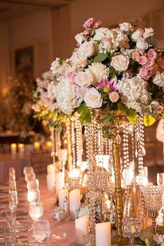 the centerpieces are adorned with crystal beads and flowers, along with candles in glass vases