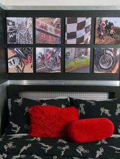 a bed with red pillows and pictures on the wall